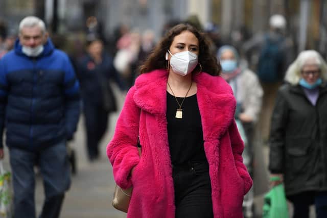 A shopper wears a facemask (Photo by OLI SCARFF/AFP via Getty Images)