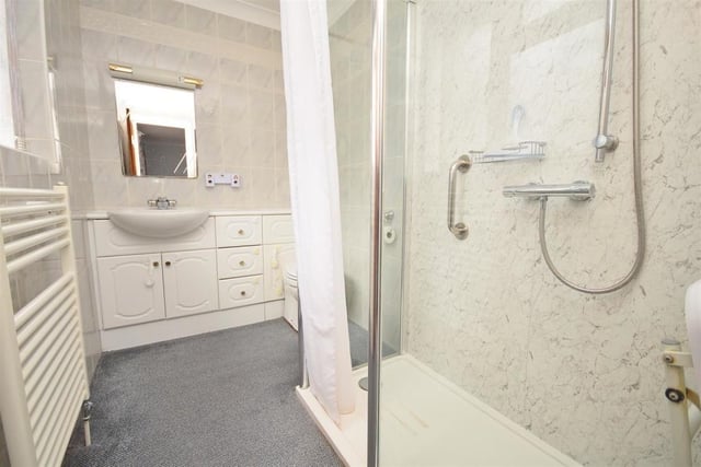 The en suite to the master bedroom comprises a double shower-tray with mixer shower over, wash basin with vanity storage below, and low-level WC with concealed cistern. The room is completed by tiled walls,, a radiator and extractor fan.