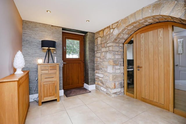 Entering the front door at The Lawns, you are greeted by this hall, which is distinguished by exposed, natural stone walls, a ceramic tiled floor and inset ceiling lighting.