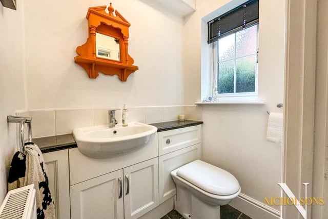 The downstairs toilet consists of a wash hand basin, set within a vanity unit with cupboards beneath, and a dual-flush WC.