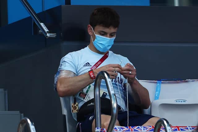 Tom Daley of Team Great Britain is seen knitting in the stands during the Men's 3m Springboard Final on day eleven of the Tokyo 2020 Olympic Games(Photo by Clive Rose/Getty Images)