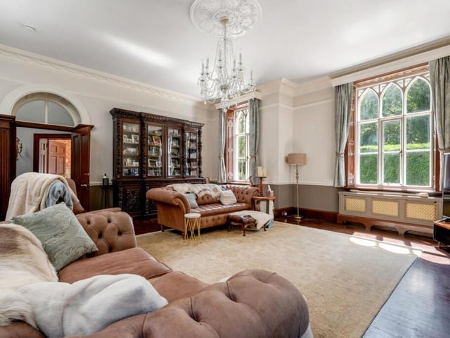 A stunning reception room with original decor detail and feature windows.