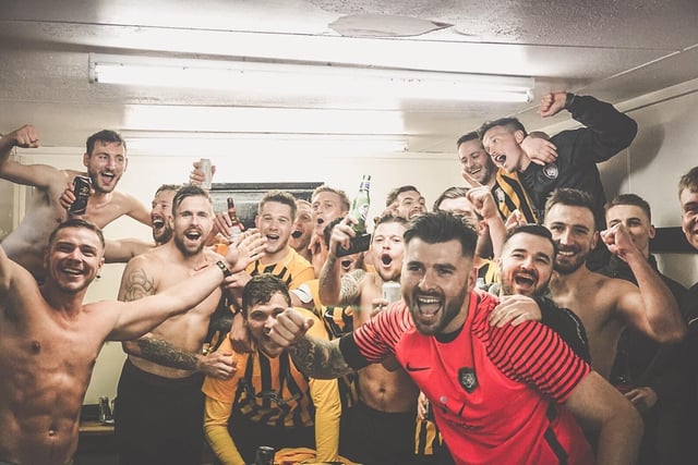 The players celebrate in the changing rooms after lifting the league title.