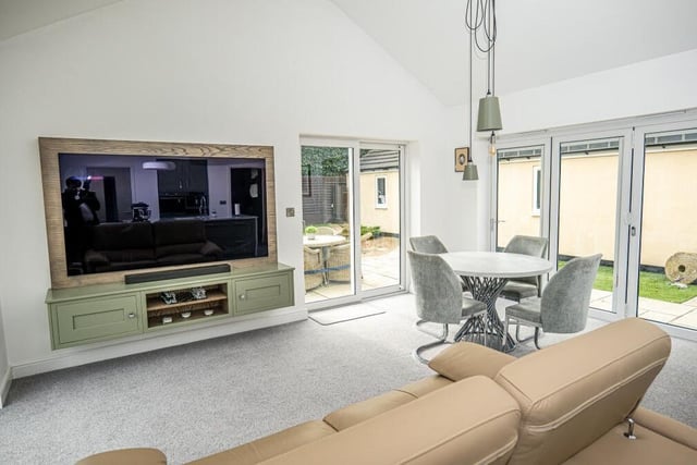Here is the living and dining section of the open-plan hub. It has a bright and airy feel, thanks partly to sets of bi-folding doors that lead out to the garden.