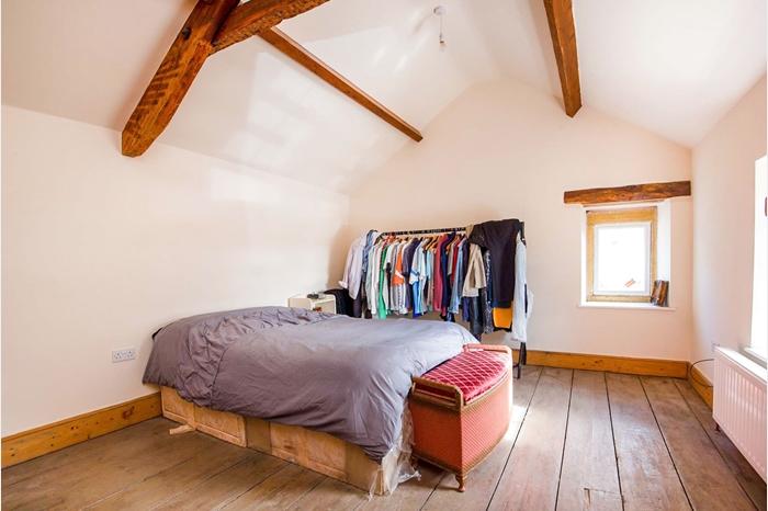 With original A frame exposed beam to the ceiling, wide-planked wooden flooring and a useful walk-in wardrobe/store cupboard. This double-aspect bedroom has a double-glazed window to the side and a double-glazed sash window to the front. The room also has a wall mounted central heating radiator.