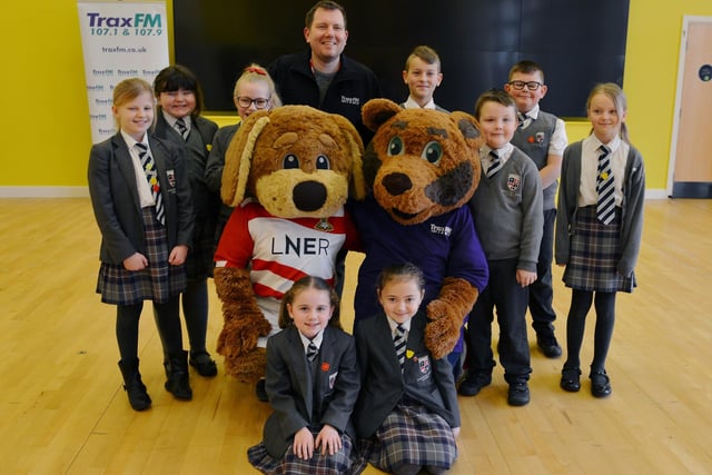 Sparken Hill Academy were given tickets to see Doncaster Rovers in action after winning a competition with Trax FM, Traxie Bear and Donny Dog celebrate with the children