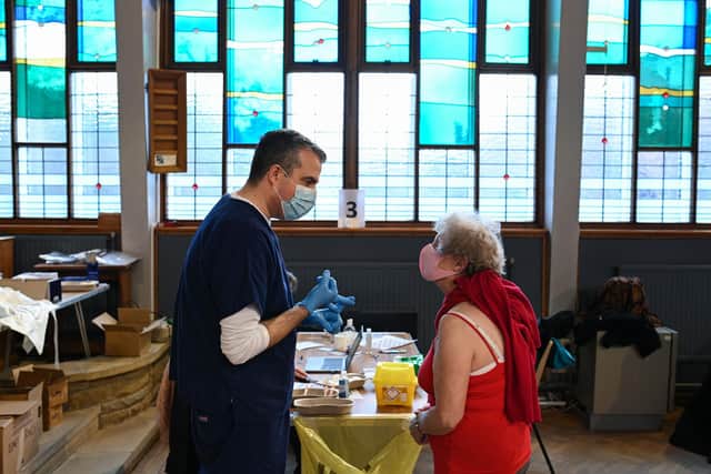 Doctor Chris Parry speaks with a member of the public before administering the Oxford/AstraZeneca Covid-19 vaccine at a temporary vaccination centre (Photo by OLI SCARFF/AFP via Getty Images)