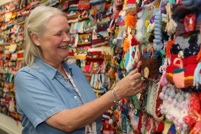 Julie Benjafield with the spectacular Twiddlers exhibit made by knitters across the county