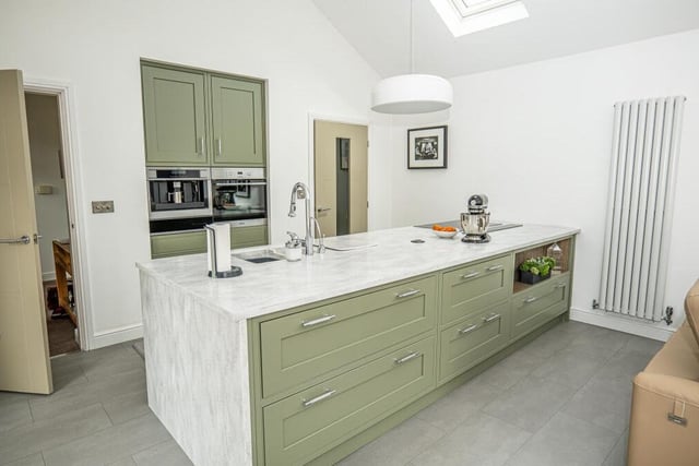 The classy bespoke kitchen contains a large breakfast island, with Corian work surfaces and high-quality Miele appliances that include a dishwasher and an induction hob with  downdraft extractor.