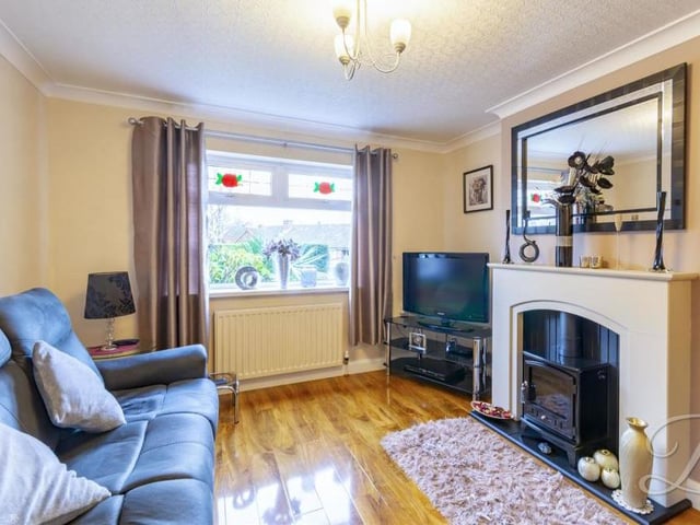 A beautiful feature fireplace gives this living room a warm and homely feel. There are windows to the front and side of the bungalow.
