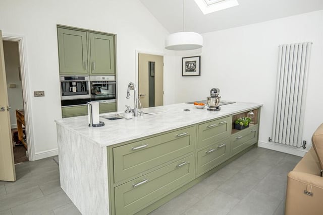 The brilliant, bespoke kitchen, with its large breakfast is;land, benefits from Corian work surfaces and Miele appliances, including an induction hob with a downdraft extractor, dishwasher and built-in microwave.