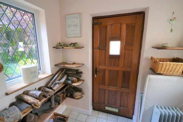As we step inside the front door, we are greeted by an entrance porch, with side windows. It is the perfect place to remove coats and shoes -- and to keep logs for the sitting room fire.
