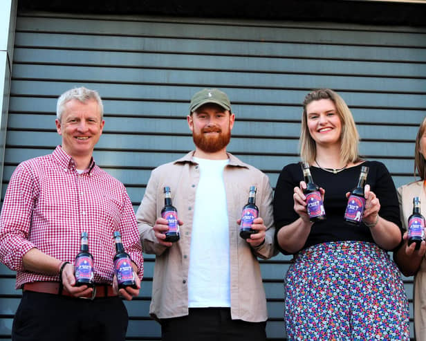 Showing off the special purple bottles are, from left: Matt Davies (Henderson's general manager), artist Luke Horton, Pip Colley and Ruth Wallbank (both Bluebell Wood). Photo: Submitted