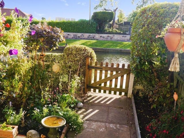 There can't be many prettier sights from a front door than this. A garden containing a variety of plants, flowers and shrub borders and only a wooden gate separating the cottage from the side of a picturesque canal.