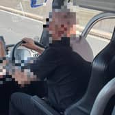 The driver was pictured using his mobile phone while driving a coach full of passengers.