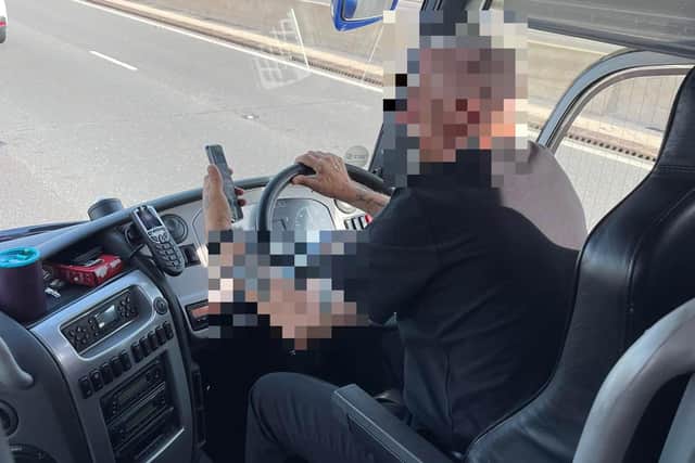 The driver was pictured using his mobile phone while driving a coach full of passengers.