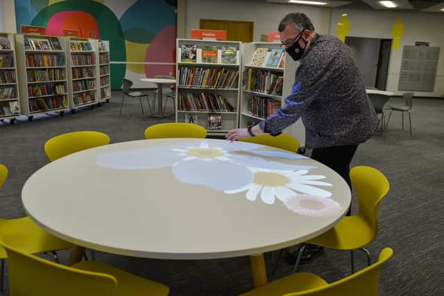 Worksop Library, Principal Library Manager Steve Powell trys out the new interactive table in the children's section