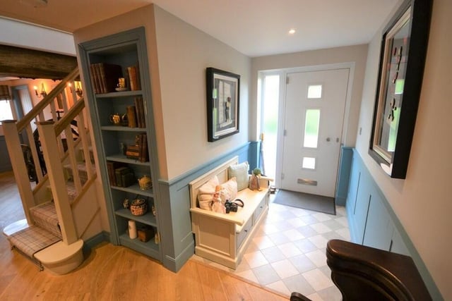 Through the front door and into an attractive reception hall, which has a tiled floor leading to an engineered oak floor with underfloor heating. The book shelf you see is actually a door opening to a secret cupboard that houses the entire underfloor heating system for downstairs!