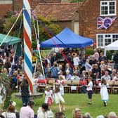 Children dancing round the maypole at Wellow's annual event watched by large crowds