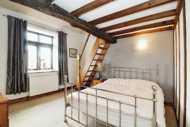 Of the other two bedrooms, this one is particularly attractive, with its pitched beamed ceiling, Velux skylight window and fixed pine staircase to a mezzanine level.