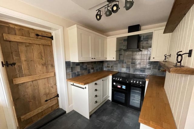 Here is the newly-fitted kitchen with base and eye-level units. It features a range cooker point and extractor, sink, integrated fridge freezer, washing machine and dishwasher