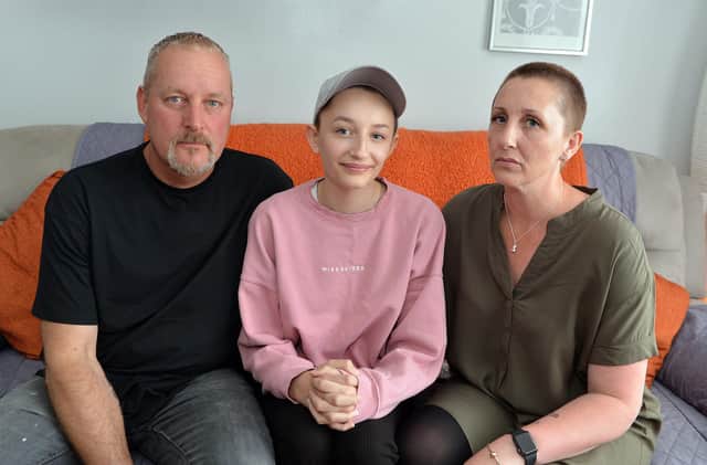 Ella Goodwin, 13, seen with parents Shaun and Joanne has lost her hair due to illness. She doesn't want to wear a wig but is being told by the school she cannot wear a cap as uniform.