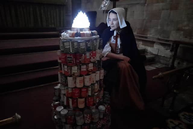 Pilgrim with can-dle at St Swithun's Church.