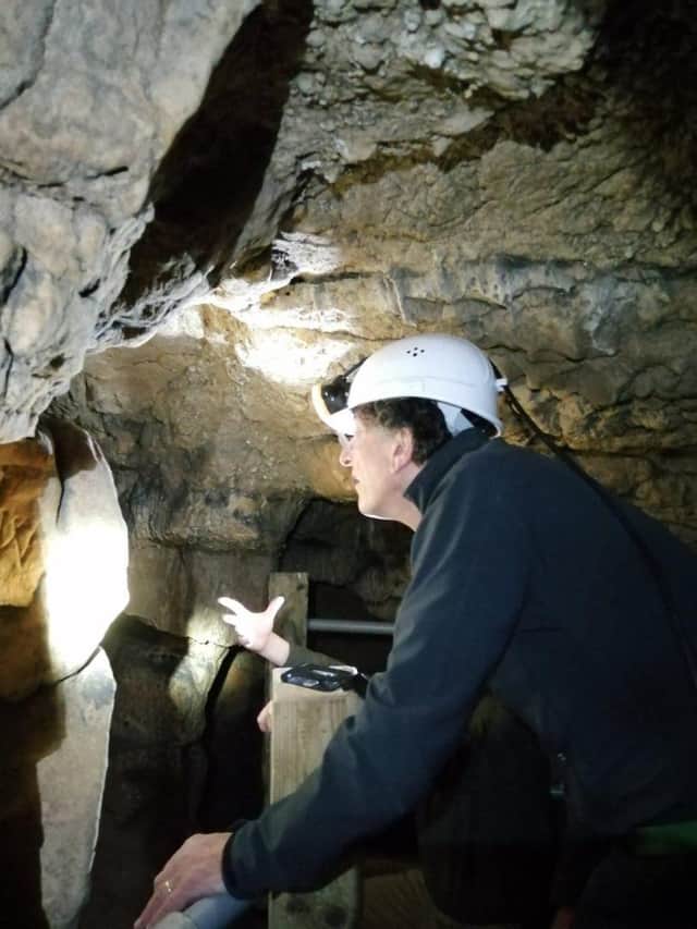 Sir Antony Gormley exploring Robin Hood Cave.
