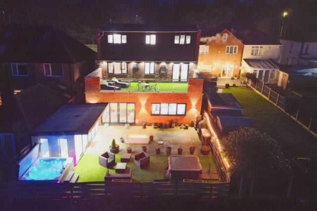 The final photo of our gallery shows the property in all its illuminated glory from the back.