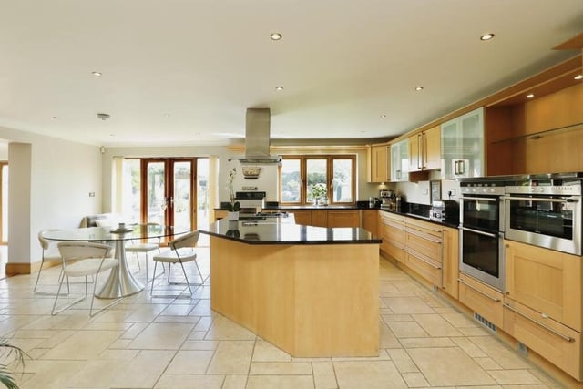 Let's begin our tour of the Green Farm Court home in the bespoke kitchen, breakfast and family area. The contemporary kitchen overflows with fitted appliances.