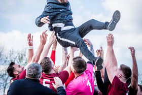 Players throw Craig Denton into the air after winning promotion.