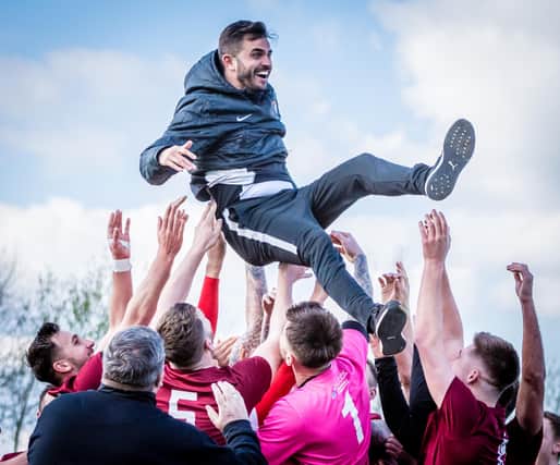 Players throw Craig Denton into the air after winning promotion.