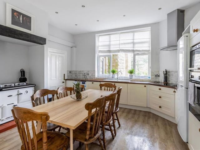 Opposite the drawing room at Oakerthorpe Manor is this pleasant kitchen and breakfast room. It features integrated appliances, including ample storage, wood-effect flooring, spotlights and a Rayburn Royal range cooker.