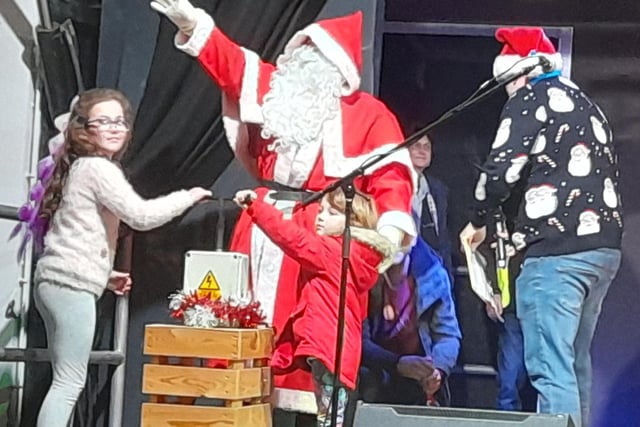 Santa's little helper was assisted by his sister as he switched on the town's Christmas lights.