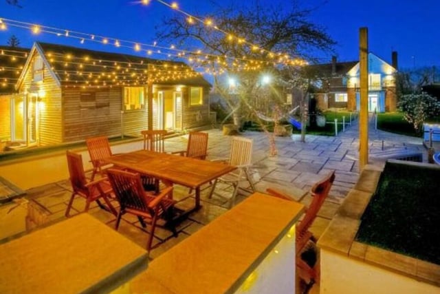 The garden can be lit up at night, and this patio area provides the ideal setting for entertaining family or friends during warm summer evenings.