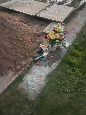The flowers had been moved to the side by gravediggers.