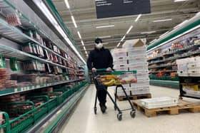 AS supermarket shopper wearing a mask in Finland (Photo by OLIVIER MORIN/AFP via Getty Images)