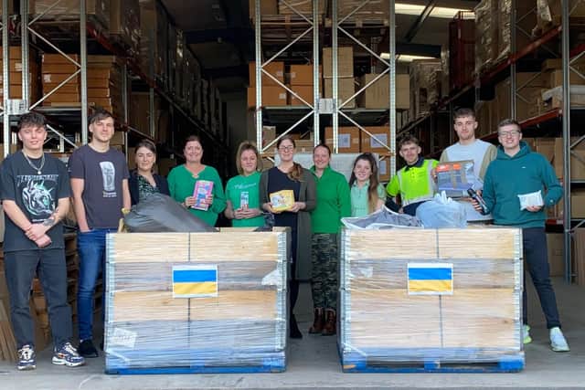 Melody Masion staff sporting green for St Patrick's Day,  around the pallets which were sent to the Ukraine border.
