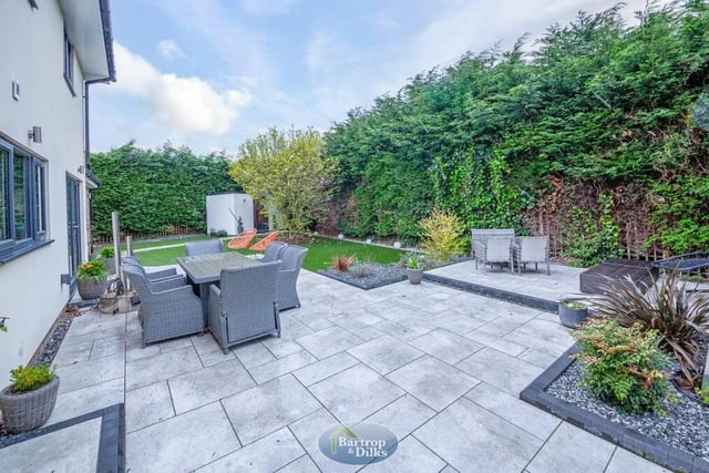 As we step outside, let's take a look at the impressive, landscaped rear garden. Private, enclosed and not overlooked, it features an artificial lawn and a porcelain patio with seating areas.