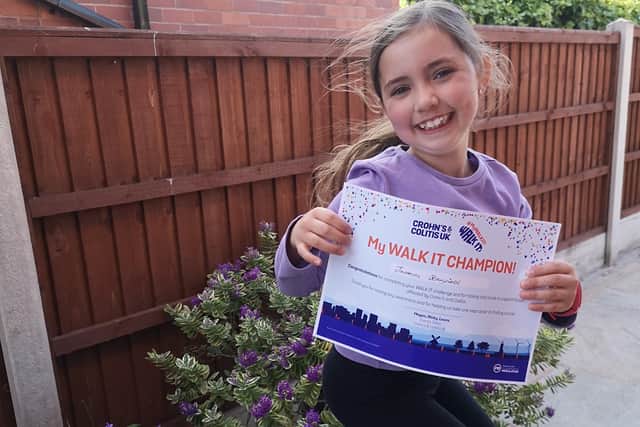 Jasmine Stanfield, seven, with her certificate for completing the Chron's and Colitis UK Walk It challenge.