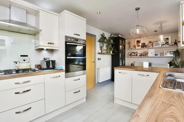 The kitchen blends high quality with contemporary living. It is fitted with an extensive range of high-gloss units, worktops and a sink-and-a-half with drainer and mixer tap. Integrated appliances include a double electric oven, gas hobs with extractor fan, fridge, freezer and dishwasher.
