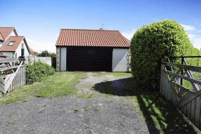 A driveway, accessed from a private lane at the back of the property and providing off-street parking space, also leads to this detached double garage.