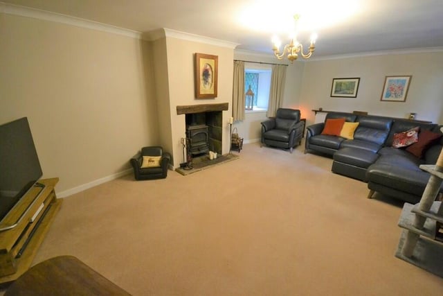 At the heart of the generously sized sitting room is a feature fireplace with multi-fuel-burning stove.