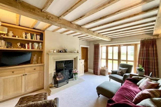 Moving on now to the cosy snug, which provides a charming and informal sitting area with a Yorkshire Range fireplace, bespoke cabinetry and French doors opening on to the side and rear garden.