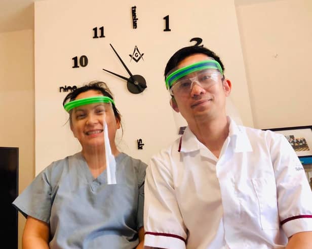 Nottinghamshire Freemason Ken Chui, a hospital radiographer, and his wife Gladys who is a carer, with two of the face masks