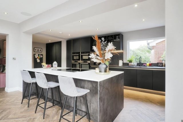 As well as the induction hob in the central island, integrated appliances within the kitchen include no fewer than four ovens and a dishwasher. The window gives views of the back garden, and close by is a utility room with space for a washing machine and tumble dryer..