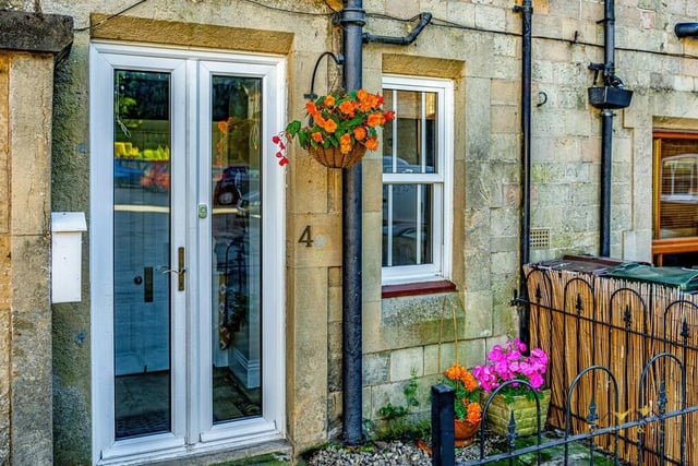 The welcoming front entrance to the characterful property, which leads to an inviting hallway that gives access to the kitchen and the downstairs WC, as well as steps down to the lounge.