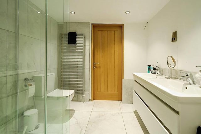 There are two bathrooms at the £825,000 property. This sparkling one boasts a marble-effect, tiled shower enclosure, impressive double wash hand basin and low-flush WC. There is also a marble-look, tiled floor and a chrome vertical radiator.