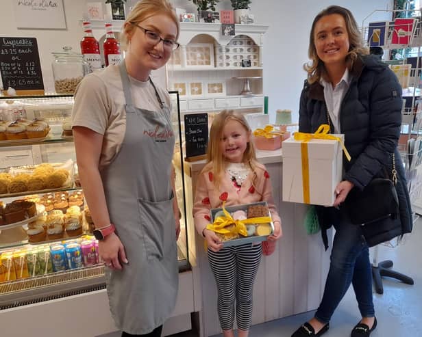Jade welcomes Sofia and Phoebe to collect the Retford Easter Egg Hunt prize from Nicole Olivia's Cake Designs