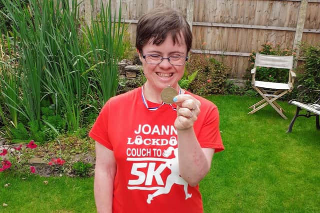 Jo proudly shows off her Couch to 5K medal and t-shirt